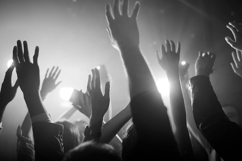 A group of people raise their hands in the air at a concert or event, illuminated by bright stage lights in a black and white setting—capturing the energy reminiscent of balancing fiduciary duty and strategy in board meetings. A group of people raise their hands in the air at a concert or event, illuminated by bright stage lights in a black and white setting—capturing the energy reminiscent of balancing fiduciary duty and strategy in board meetings.